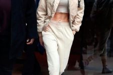 a grey turtleneck crop top, neutral joggers, white combat boots, a tan bomber jacket by Gigi Hadid