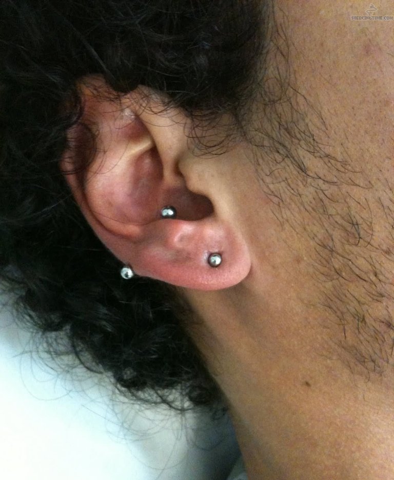 a lobe plus inner onch piercing done with matching silver jewelry for a super daring look
