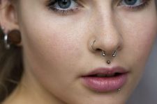 a medusa and dolphin bites piercings with studs and a nose and septum piercings for a bold look