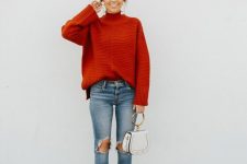 a red ribbed oversized turtleneck sweater, blue ripped jeans, brown booties and a white bag