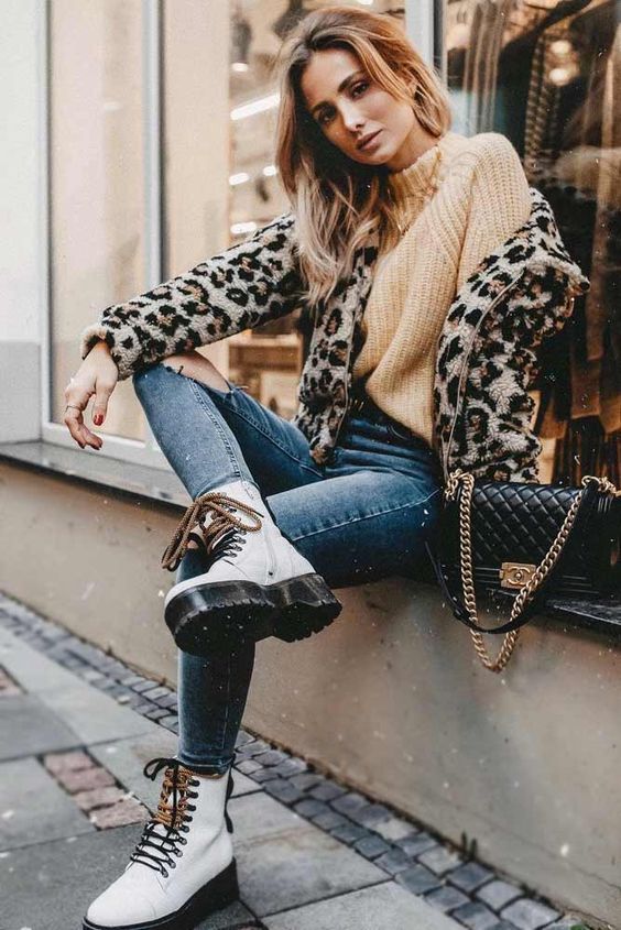 a sandy chunky sweater, blue skinnies, white combat boots, a leopard jacket and a black bag