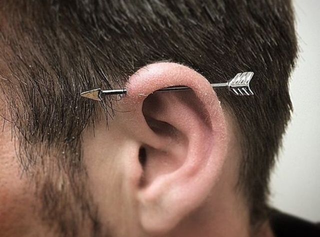 a simple horizontal industrial piercing with an arrow barbell is always a catchy idea