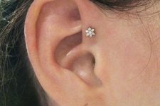a single ear piercing – a forward helix one done with a chic floral stud