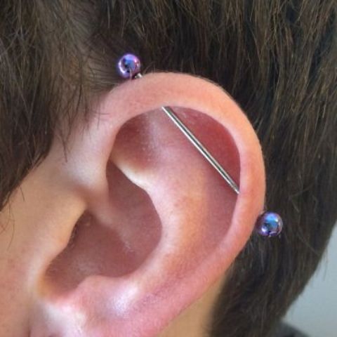 a single industrial piercing done with a bar with shiny purple beads is a bold and creative idea