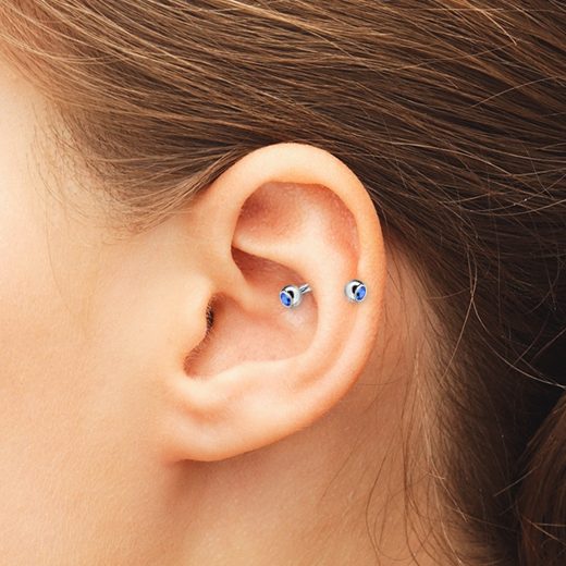a single snug piercing with a blue rhinestone earring is a bold and catchy idea to try