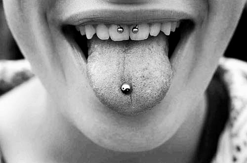 a smiley piercing paired with a tongue one for a bold and catchier look