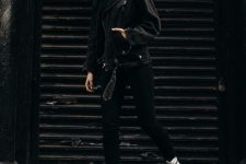 a total black look with a sweater, skinnies, a denim moto jacket refreshed with white combat boots