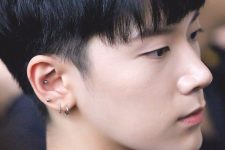 a triple lobe piercing plus a conch one with shiny silver earrings and studs for a contemporary feel