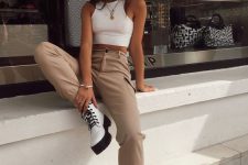a white halter neckline crop top, tan cargo pants, white combat boots and layered necklaces