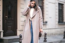 a white top, blue cropped jeans, light pink shoes, a dusty pink coat and a small bag