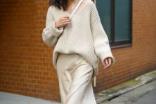 an oversized white ribbed sweater, a midi slip skirt, white sneakers and a bag