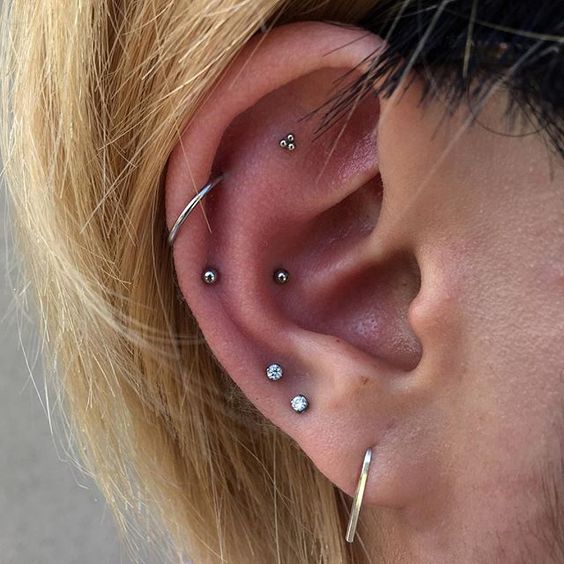 layered piercings - lobe, flat, snug and helix ones for a chic look