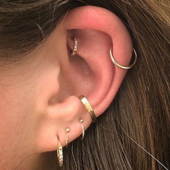 multiple layered piercings including a delicate gold diamond hoop in the rook look chic