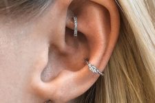 stylish ear piercings done with diamond studs and hoops including a shiny hoop in the rook