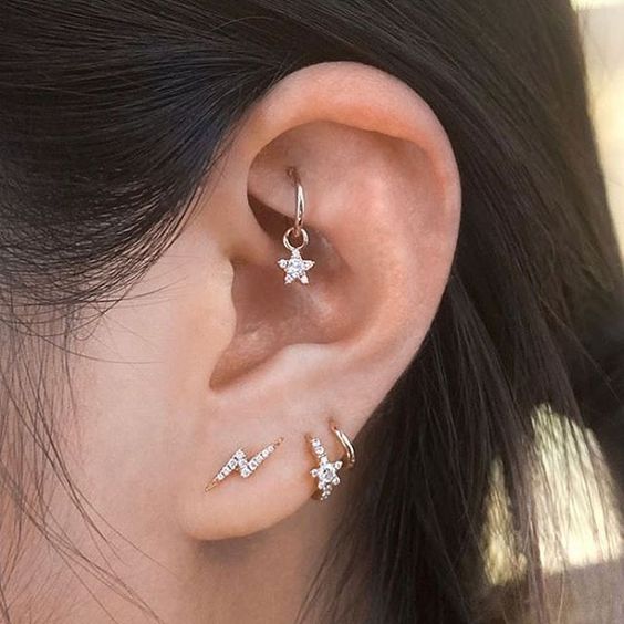 stylish gold and diamond studs in piercings and a cool hoop with a star in the rook