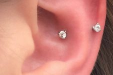 stylish minimal ear piercings – a lobe and a sung one with elegant shiny earrings