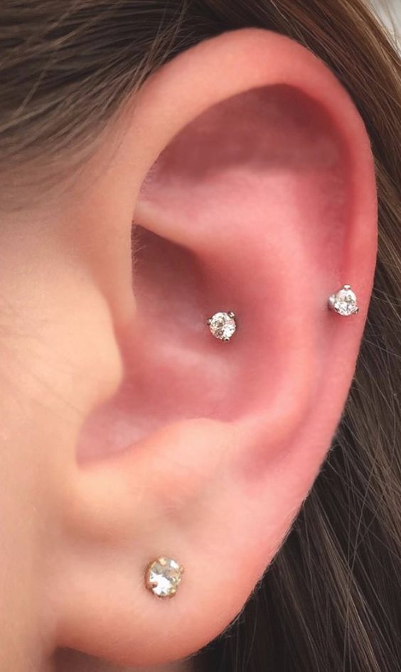 stylish minimal ear piercings - a lobe and a sung one with elegant shiny earrings
