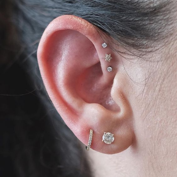 two lobe piercings paired with three forward helix ones for a bold modern look