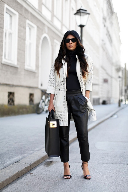 With black turtleneck, black leather pants, tote bag and high heels