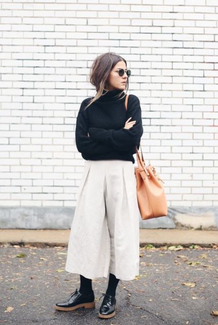 With black turtleneck, brown tote bag and black flat shoes