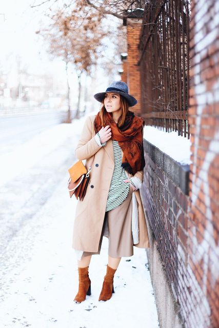 With gray hat, striped shirt, beige coat, brown suede boots and scarf