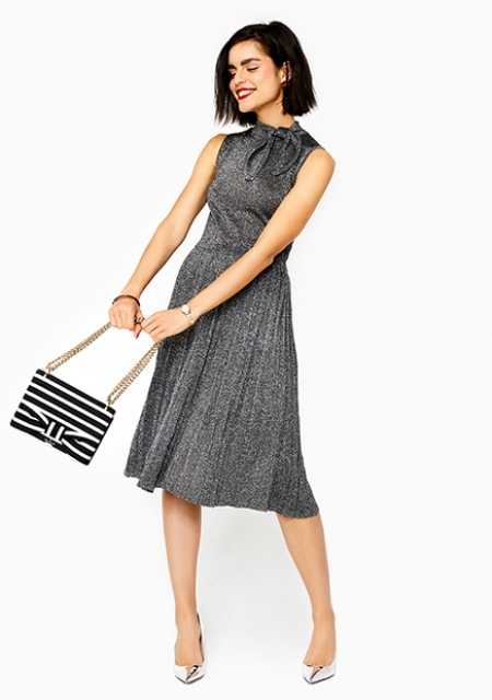 With gray pleated dress and silver pumps