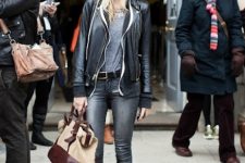 With gray t-shirt, black leather jacket, gray jeans and beige and brown bag