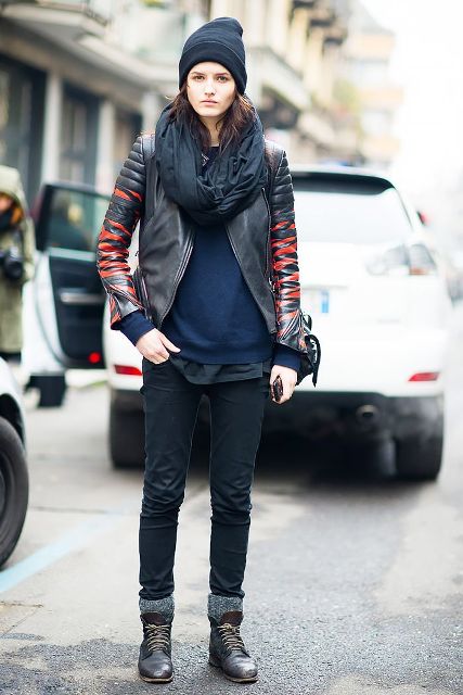 With navy blue sweater, black scarf, red and black leather jacket and black jeans