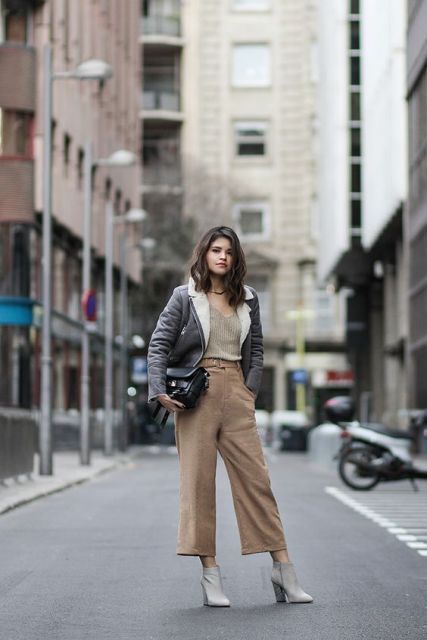 With top, gray jacket, black clutch and gray ankle boots