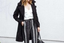 With white V-neck top, black coat, black bag and lace up flat shoes