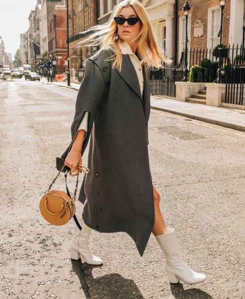 With white dress, gray loose coat and brown rounded bag