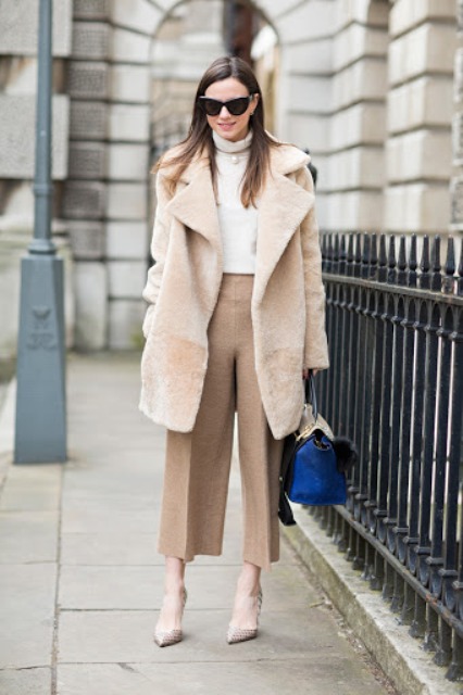 With white sweater, beige fur coat, printed pumps and bag