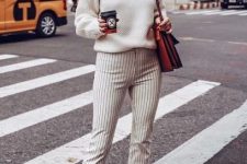 With white sweater, brown bag and brown leather mid calf boots
