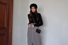 a black turtleneck, a black beret, bag and boots plus a monochromatic midi skirt of tweed