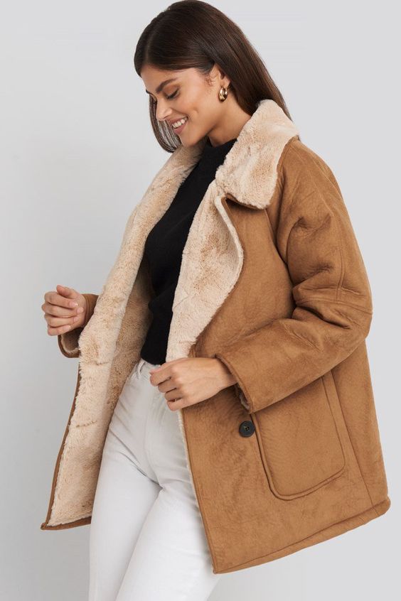 a brown oversized shearling coat with tan fur is a stylish winter outerwear piece to go for