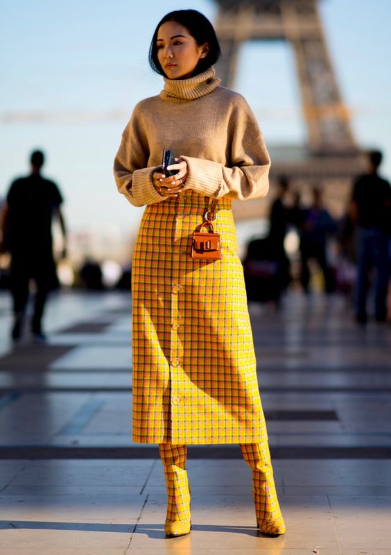 a camel sweater, a bright yellow midi skirt on buttons, matching boots and a tiny bag for a bold look