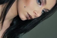 a cheek piercing plus a tunnel one and a dark lip for a very bold and rebellious look