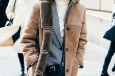 a chic winter look with a white turtleneck, blue jeans, a plaid blazer, a tan shearling coat and a bag