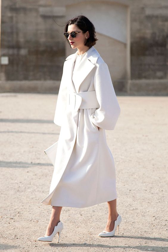 a gorgeous white midi coat, white laser cut shoes, a white clutch and a sculptural belt for a statement