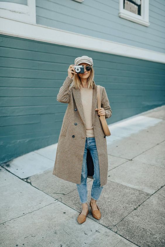 a tan sweater, blue skinnies, tan moccasins, a plaid midi coat and a gray cap for fall or winter