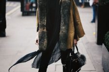 a total black outfit with skinnies, a sweater, dark snakeskin print boots and a mustard shearling coat with much fur