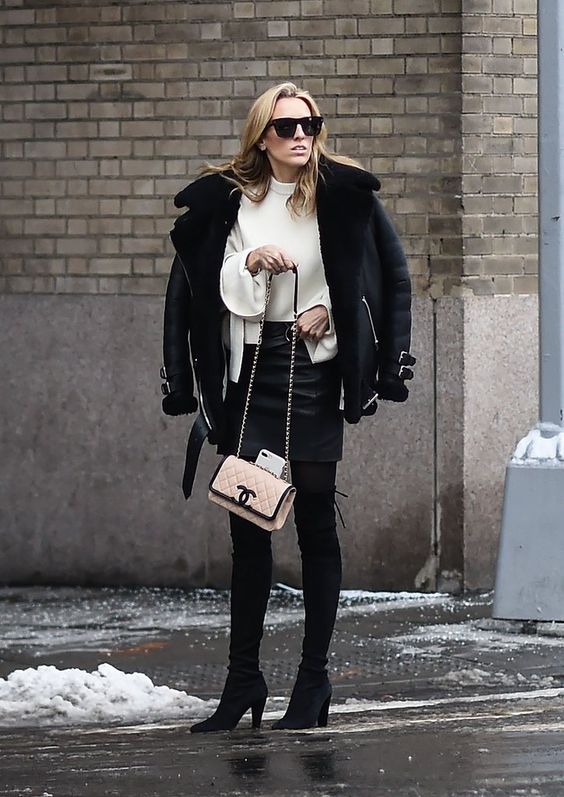 a white sweater, a black skirt, boots, a black short shearling coat and a blush bag for winter