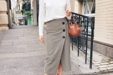 a white top with long sleeves, a tweed button midi, red boots and a brown mini bag