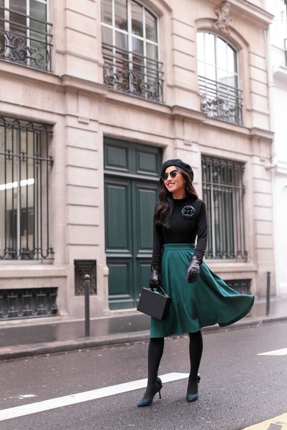 Parisian-style Christmas look with a black top, a green circle skirt, black tights, green shoes, a beret and a box bag
