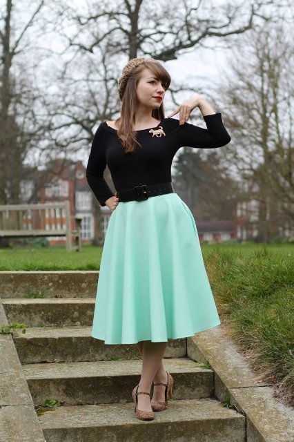 With black shirt, black belt, mint green midi skirt and printed shoes