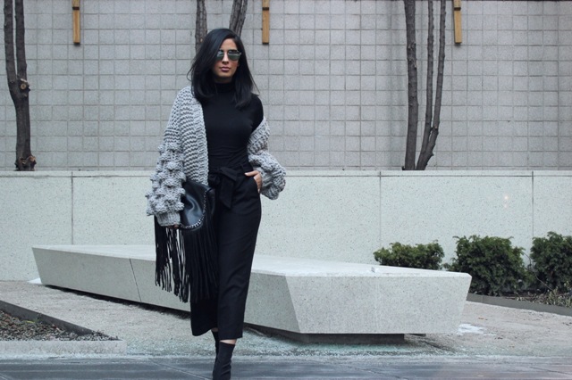 With black turtleneck, black culottes, mid calf boots and fringe clutch