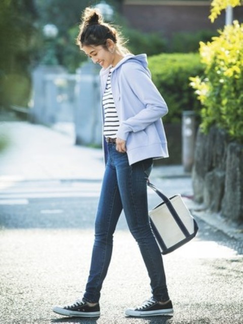 With striped shirt, skinny jeans, black and white tote bag and sneakers