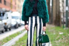 With turtleneck, striped trousers and green leather bag
