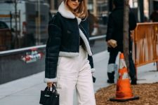 a black turtleneck, white cargo pants, black Chelsea boots, a denim jacket with a small bag