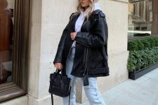a casual winter look with a white hoodie, light blue jeans, black Chelsea boots, a black leather jacket and a bag